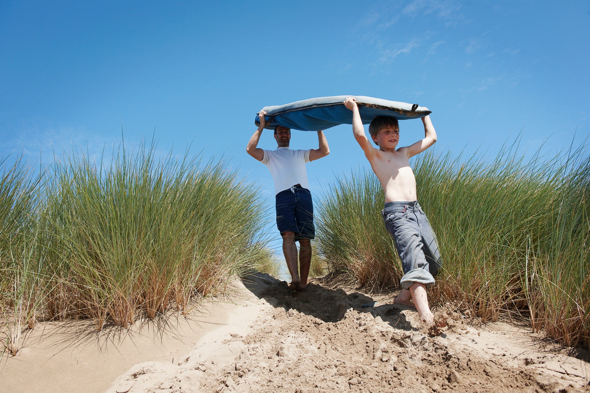 Father and Son Carrying Surf board